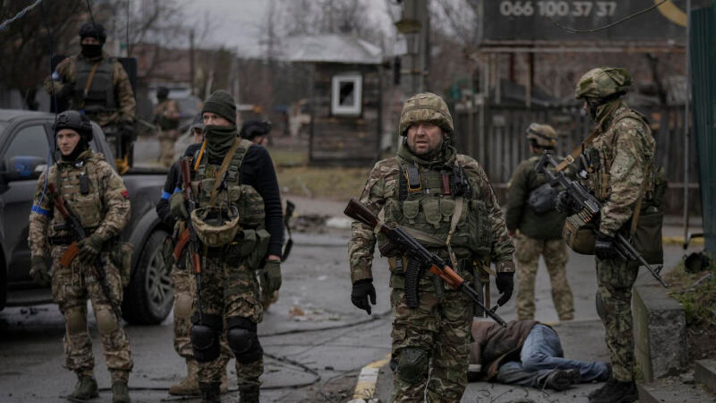 Ukrainische Soldaten stehen inmitten von Butscha und untersuchen die Leichen von Zivilisten auf Sprengfallen Ukrainische Soldaten stehen inmitten von Butscha und untersuchen die Leichen von Zivilisten auf Sprengfallen