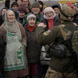 Ein ukrainischer Soldat spricht zu einer Gruppe von älteren Männern und Frauen