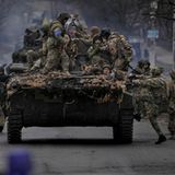 Ukrainische Soldaten klettern auf ein Militärfahrzeug des ukrainischen Militärs.