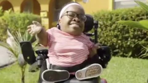 Die kleinste Frau der Welt in ihrem Rollstuhl im Garten vor ihrem Haus