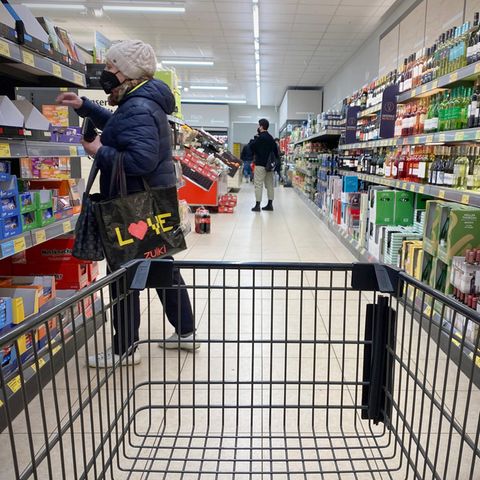 Ein leerer Einkaufswagen wird durch die Gänge eines Discounters geschoben.