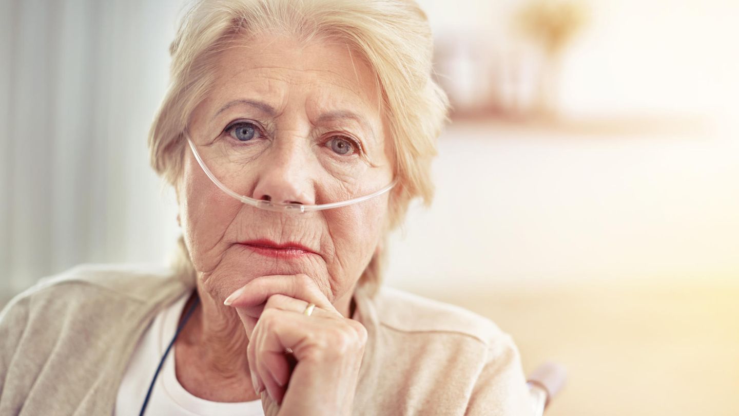Eine Frau um die 80 trägt hat Schläuche in der Nase durch ein Sauerstoffgerät Eine Frau um die 80 trägt hat Schläuche in der Nase durch ein Sauerstoffgerät