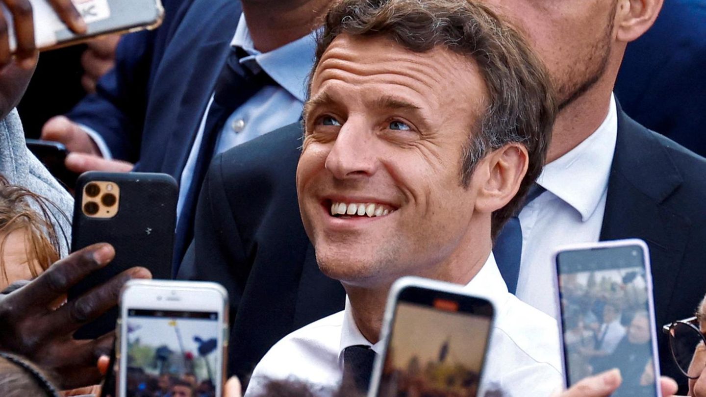French President Emmanuel Macron, candidate for his re-election in the 2022 French presidential election, reacts as supporters use mobile phones during his campaign in Dijon, France March 28, 2022. REUTERS/Gonzalo Fuentes Emmanuel Macron am 28. März in Dijon umlagert von Fotografen
