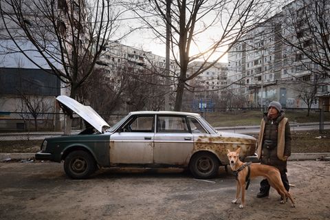 Eine junge Frau mit Hund im zerbombten Charkiw