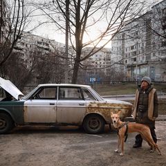 Eine junge Frau mit Hund im zerbombten Charkiw