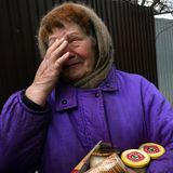 Weinende Frau aus Butscha hält Verpflegung im Arm