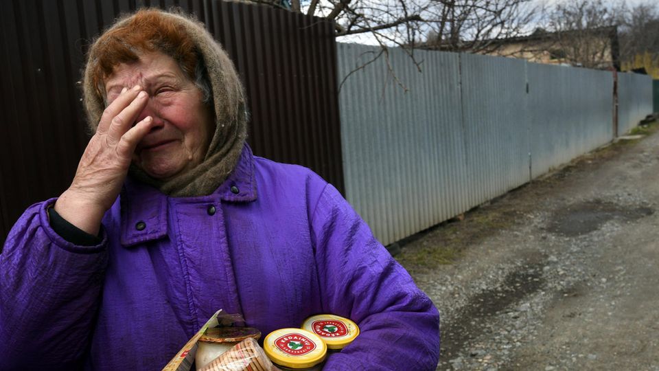 Weinende Frau aus Butscha hält Verpflegung im Arm