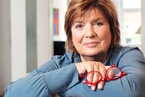 Christine Westermann lehnt sich auf einen Stapel Bücher