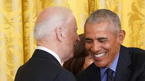 Zwei Männer in Anzügen: ein älterer Schwarzer legt lachend seine Arm um einen alten Weißen
