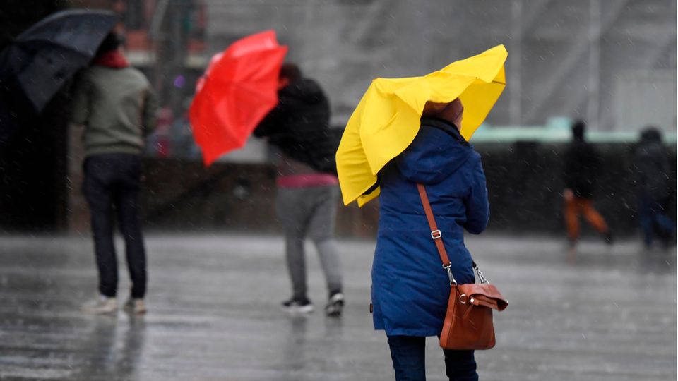 Menschen mit Regenschirmen als Symbolfoto für Wetter in Deutschland
