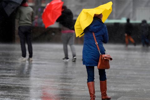 Menschen mit Regenschirmen als Symbolfoto für Wetter in Deutschland