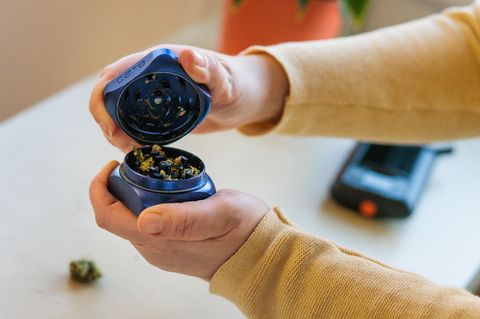 Eine Patientin öffnet einen Grinder, mithilfe dessen medizinisches Cannabis zerkleinert wurde