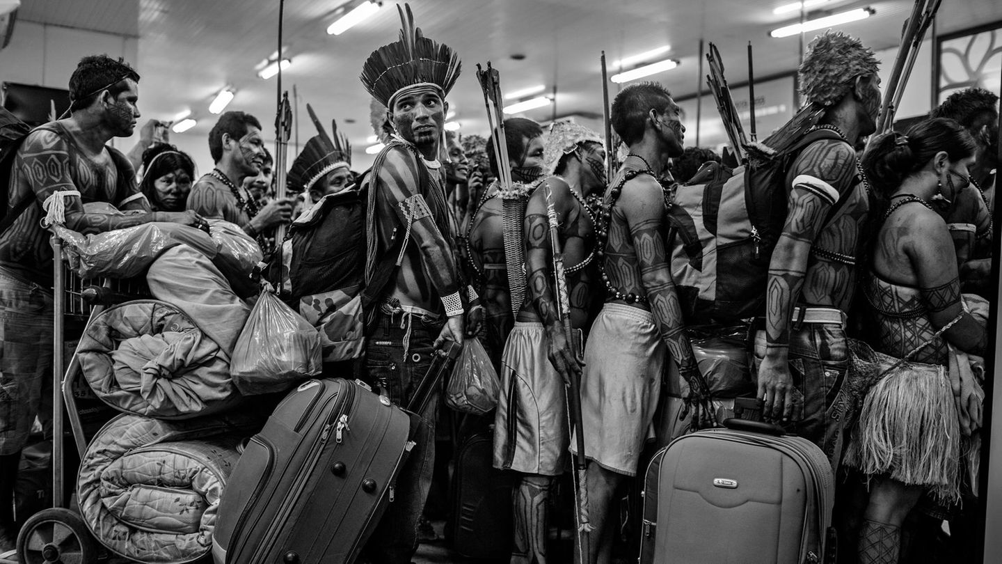 World Press Photo Long-Term Project Award Mitglieder der Munduruku-Gemeinde stehen am 14. Juni 2013 am Flughafen Altamira in Pará, Brasilien, an, um ein Flugzeug zu besteigen. Nach ihrem Protest gegen den Bau des Belo-Monte-Staudamms am Xingu-Fluss reisten sie in die Hauptstadt Brasilia, um ihren Forderungen Nachdruck zu verleihen. Die Munduruku-Gemeinschaft lebt an den Ufern des Tapajos-Flusses, einr der größten Nebenflüsse des Amazonas, mehrere hundert Kilometer entfernt, wo die Regierung den Bau weiterer Wasserkraftwerke plant. Trotz des Protestes wurde das Belo Monte Projekt 2019 fertiggestellt. Fotograf Lalo de Almeida bekommt nun den "World Press Photo Award" für sein fotografisches Langzeit-Projekt.