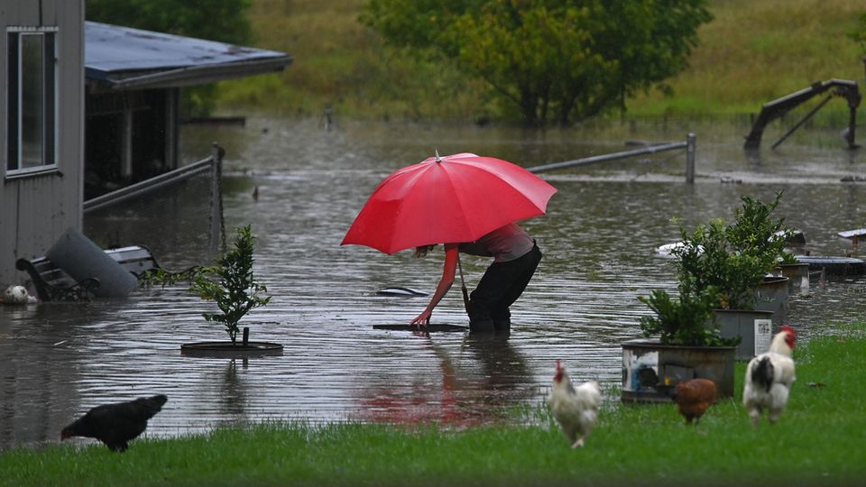 Australien Regen Überschwemmung Frau steht in ihrem überfluteten Garten in Australien