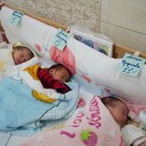 Drei Babys in einem Bettchen