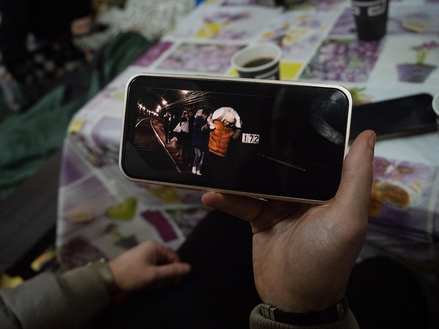 Auf seinem Handy zeigt Jewgenij wie sie Lebensmittel durch die Bahntunnel tragen, um vor Angriffen sicher zu sein