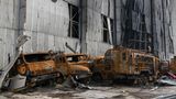 Vor dem Hangar geparkte Fahrzeuge wurden ebenfalls am Werksflughafen von Antonow in Brand geschossen.