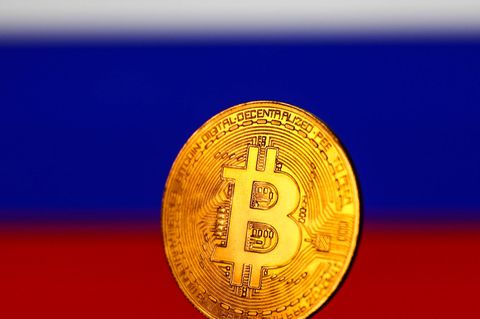 Eine fiktive Bitcoin-Münze steht vor einer Russland-Flagge