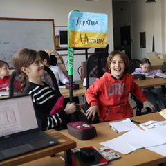 Polina und Renat amüsieren sich über eine selbstgebastelte Flagge