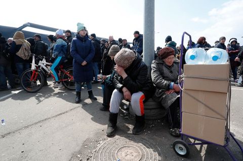 "Russische Soldaten haben sexuelle Gewalt gegen ukrainische Frauen und Männer, gegen Kinder und ältere Menschen ausgeübt": Menschen warten in Mariupol an einer Ausgabestelle für humanitäre Hilfsgüter.