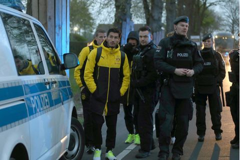 Die Dortmunder Profis Sven Bender (links hinten) und Nuri Sahin (vorne links) stehen gemeinsam mit Polizisten vor dem Teamhotel