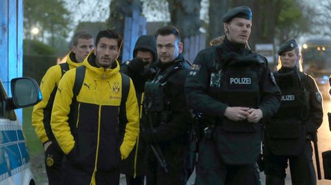 Die Dortmunder Profis Sven Bender (links hinten) und Nuri Sahin (vorne links) stehen gemeinsam mit Polizisten vor dem Teamhotel