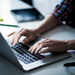 Laptop bis 400 Euro: Eine Frau sitzt am Laptop und arbeitet.