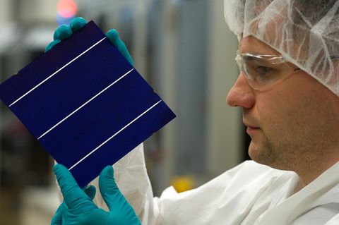 Symbolfoto zum Thema Solarzellen: Ein Forscher prüft eine Solarzelle 