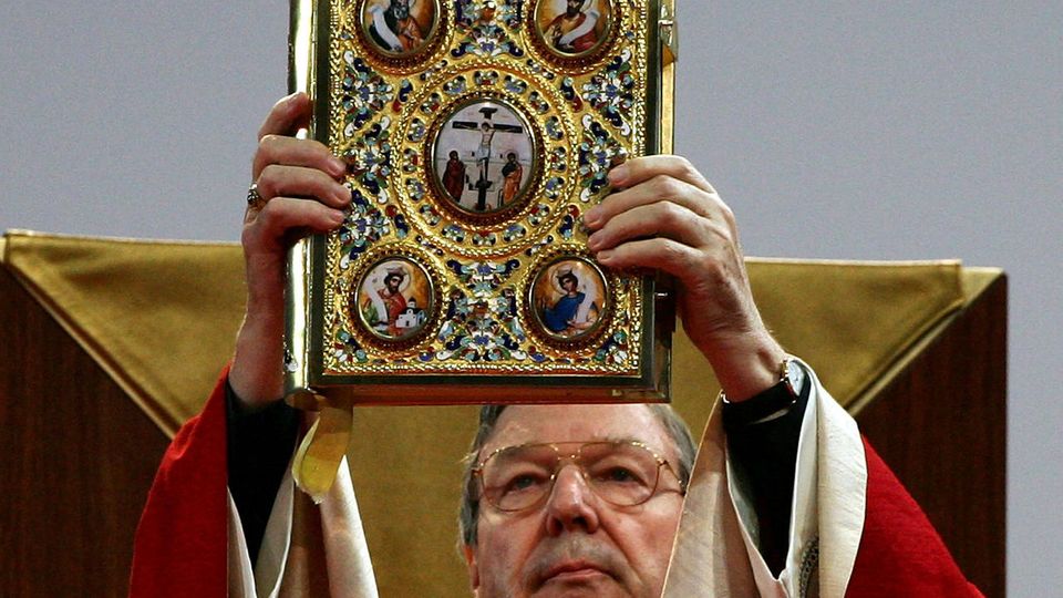 Der australische Erzbischof George Pell erhebt eine Bibel