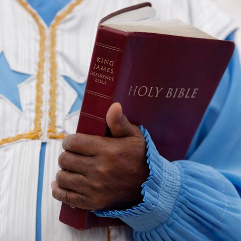 Ein Geistlicher hält die "Heilige Bibel" in seinem Arm