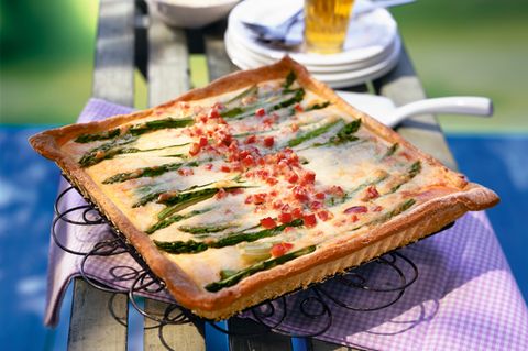 Spargelquiche      Zutaten für ca. 8 Stücke:  Für den Teig: 125 g Magerquark, 3 EL Milch, 6 EL Rapsöl, Jodsalz, 3 Eier, 150 Mehl, 1 TL Backpulver, 50 g Haferflocken blütenzart       Für den Belag: 750 g weißen Spargel, 120 g gekochter Schinken, 150 g Schmand, 150 g Mascarpone, 2 EL Instant-Haferflocken, weißer Pfeffer, 40 g geriebener Parmesan  Außerdem: Fett und Haferflocken blütenzart für die Form, getrocknete Hülsenfrüchte zum Blindbacken      Zubereitung:  Für den Teig Quark mit Milch, 4 EL Rapsöl, einer Prise Salz und einem Ei cremig rühren. Mehl mit Backpulver sowie Haferflocken mischen und unterkneten. Quicheform fetten und mit Haferflocken ausstreuen. Teig ausrollen, die Form damit auskleiden und mit einer Gabel mehrmals einstechen. Teig mit Backpapier und Hülsenfrüchten belegen und im vorgeheizten Backofen ca. 10 Minuten backen, danach ohne Hülsenfrüchte und Backpapier weitere 5 Minuten vorbacken.   Spargelstangen waschen, die Enden abschneiden, wenn nötig schälen und vierteln. 2 EL Rapsöl in einer Pfanne erhitzen und den Spargel darin andünsten.   Gekochten Schinken würfeln. Schmand mit Mascarpone, restlichen Eiern und Instant-Haferflocken verrühren. Mit Salz und Pfeffer würzen und Käse unterheben. Spargel zusammen mit Schinkenwürfeln dekorativ auf dem vorgebackenen Teig verteilen, Schmandcreme darüber geben und backen. 