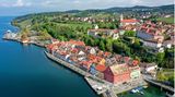 Aufnahme von Meersburg von oben mit dem Bodensee im Vordergrund und der Altstadt, am Hang das Schloss