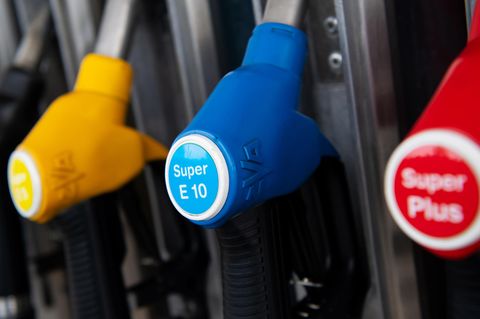Zapfpistolen für verschiedene Kraftstoffarten, darunter auch E10, hängen an einer Zapfsäule an einer Tankstelle.