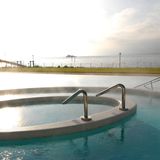 Wasser dampft im Außenbecken der Therme in Konstanz. Im Hintergrund ist der Bodensee zu sehen.