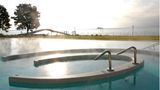 Wasser dampft im Außenbecken der Therme in Konstanz. Im Hintergrund ist der Bodensee zu sehen.