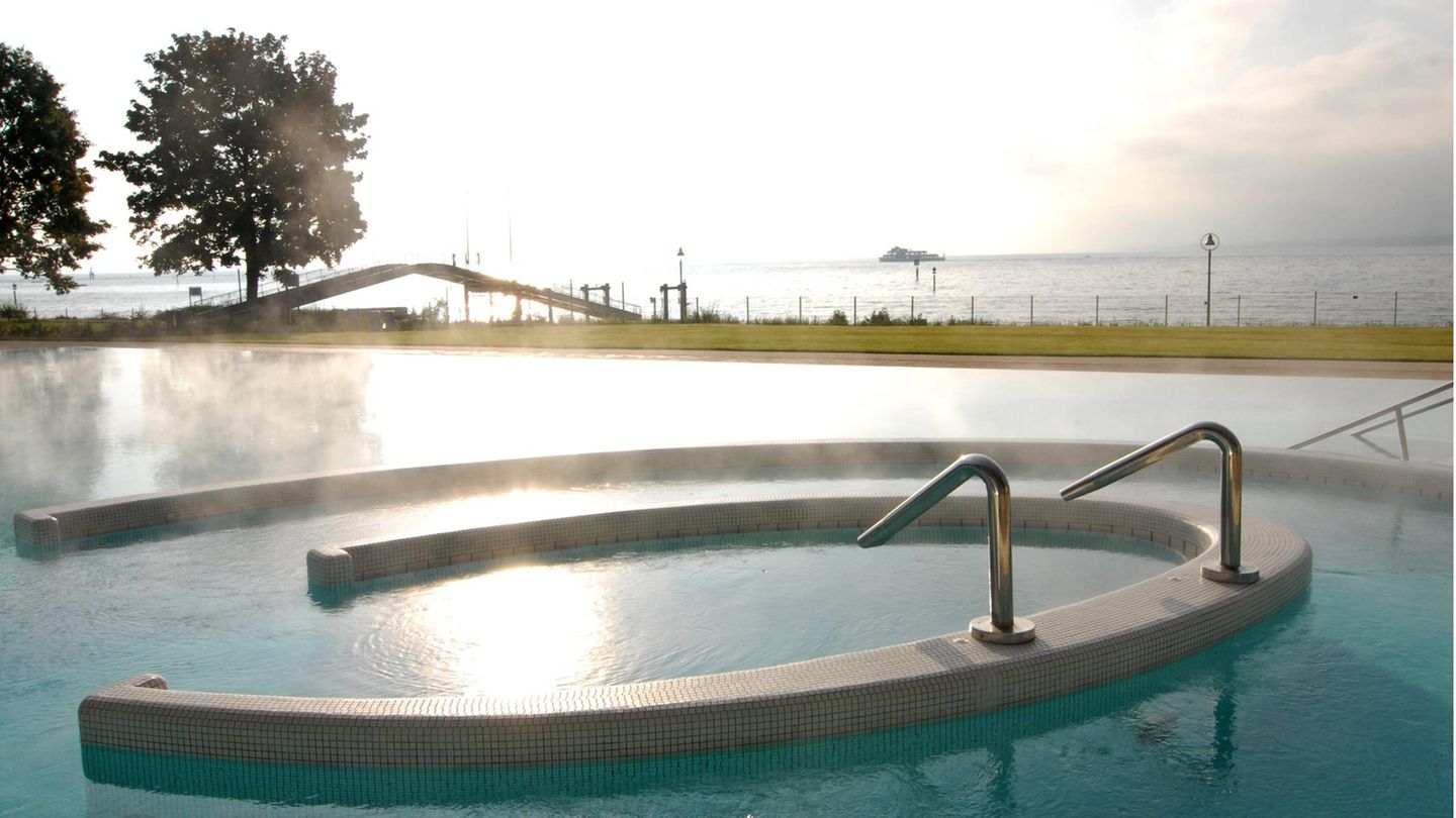 Wasser dampft im Außenbecken der Therme in Konstanz. Im Hintergrund ist der Bodensee zu sehen.