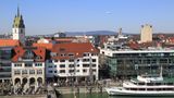 Die Uferpromenade von Friedrichshafen am Bodensee. Am Himmel fliegt ein Zeppelin.