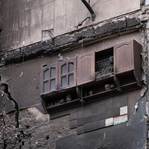 Ukraine, Borodjanka: In einem zerstörten Wohnhaus in dem befreiten Dorf Borodjanka hängt ein Küchenregal