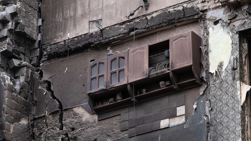 Ukraine, Borodjanka: In einem zerstörten Wohnhaus in dem befreiten Dorf Borodjanka hängt ein Küchenregal
