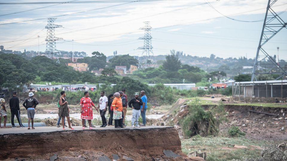 Menschen stehen auf einer zerstörten Brücke in KwaZulu-Natal, Südafrika
