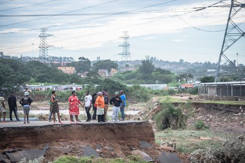 Menschen stehen auf einer zerstörten Brücke in KwaZulu-Natal, Südafrika