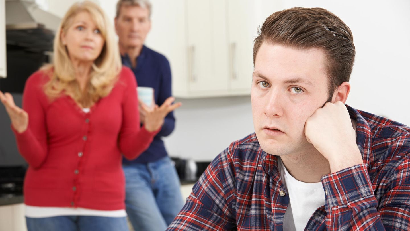 Sohn sitzt in der Küche und ist von seinen Eltern genervt