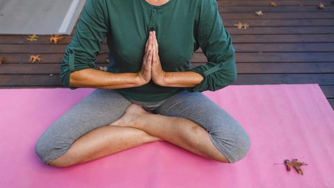 Frau beim Meditieren auf der Yogamatte