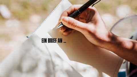 Eine Hand setzt zum Schreiben in einem Buch an