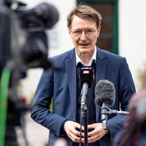 Karl Lauterbach mit Mikrofon vor Fernsehkameras