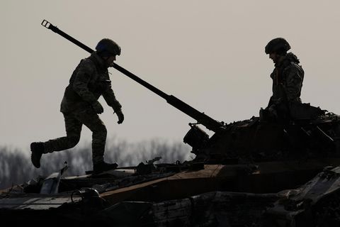 Ein ukrainischer Soldat geht an einem zerstörten russischen Kampffahrzeug in Butscha vorbei