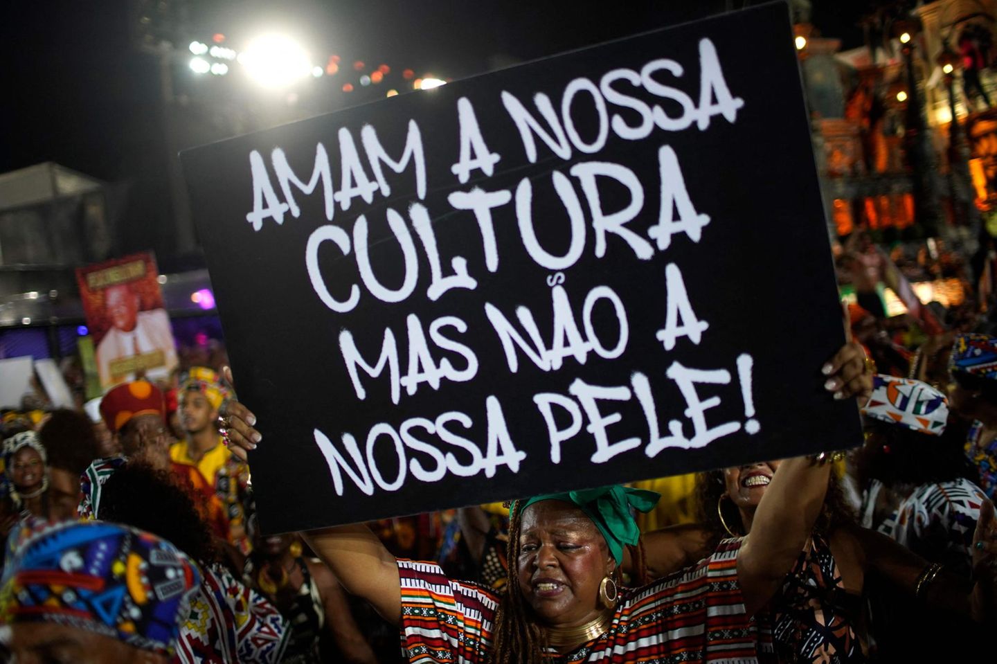 Aber auch politische und sozialkritische Botschaften fehlen nicht. Diese Tänzerin der Sambaschule Salguero trägt ein Schild mit sich, auf dem steht: "Sie lieben unsere Kultur, aber nicht unsere Haut!"