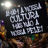 Aber auch politische und sozialkritische Botschaften fehlen nicht. Diese Tänzerin der Sambaschule Salguero trägt ein Schild mit sich, auf dem steht: "Sie lieben unsere Kultur, aber nicht unsere Haut!"