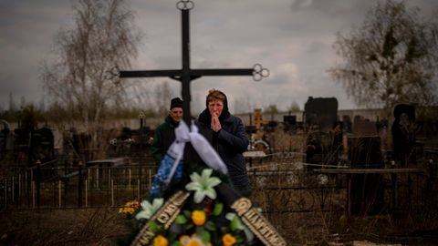 Eine Frau trauert neben dem Grab ihres Sohnes in Butscha.