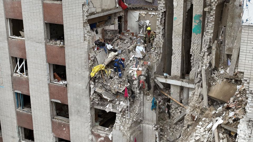 Ukraine, Tschernihiw: Feuerwehrleute sind an einem durch russischen Beschuss zerstörten Gebäude im Einsatz